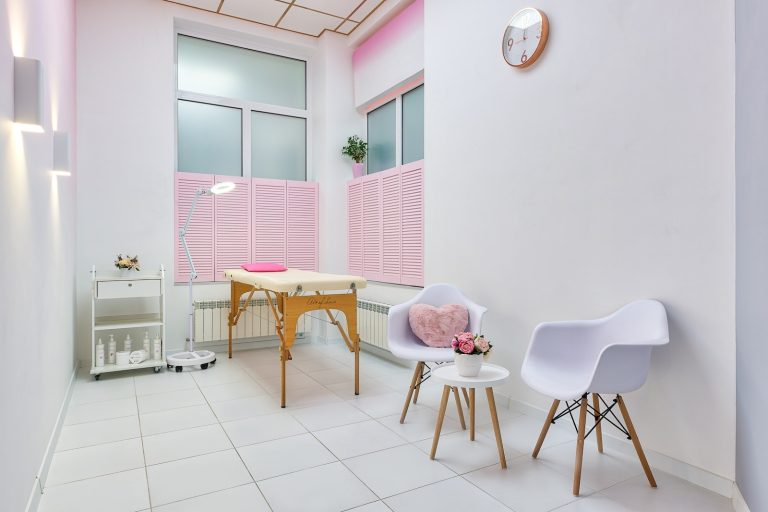 Interior of beauty salon with table for spa procedures and set of skincare products and flower decorations