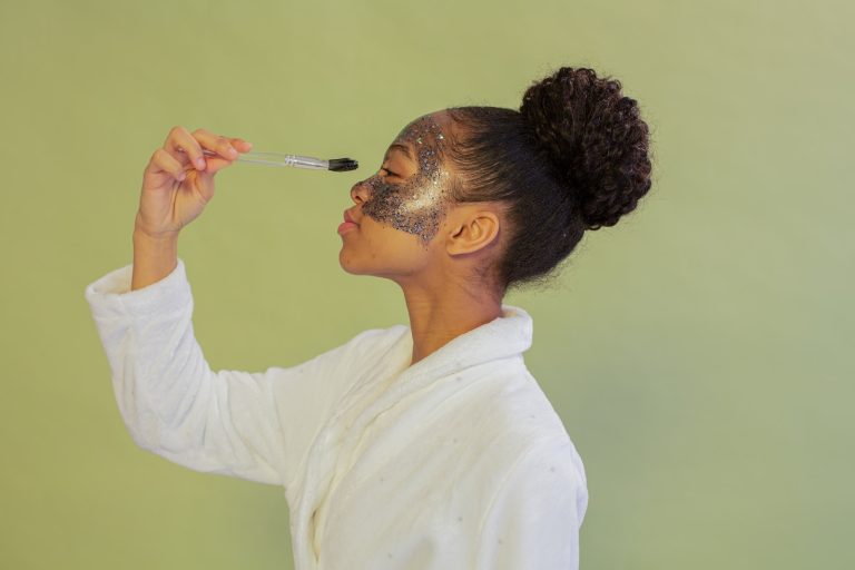 Black woman applying facial mask with brush