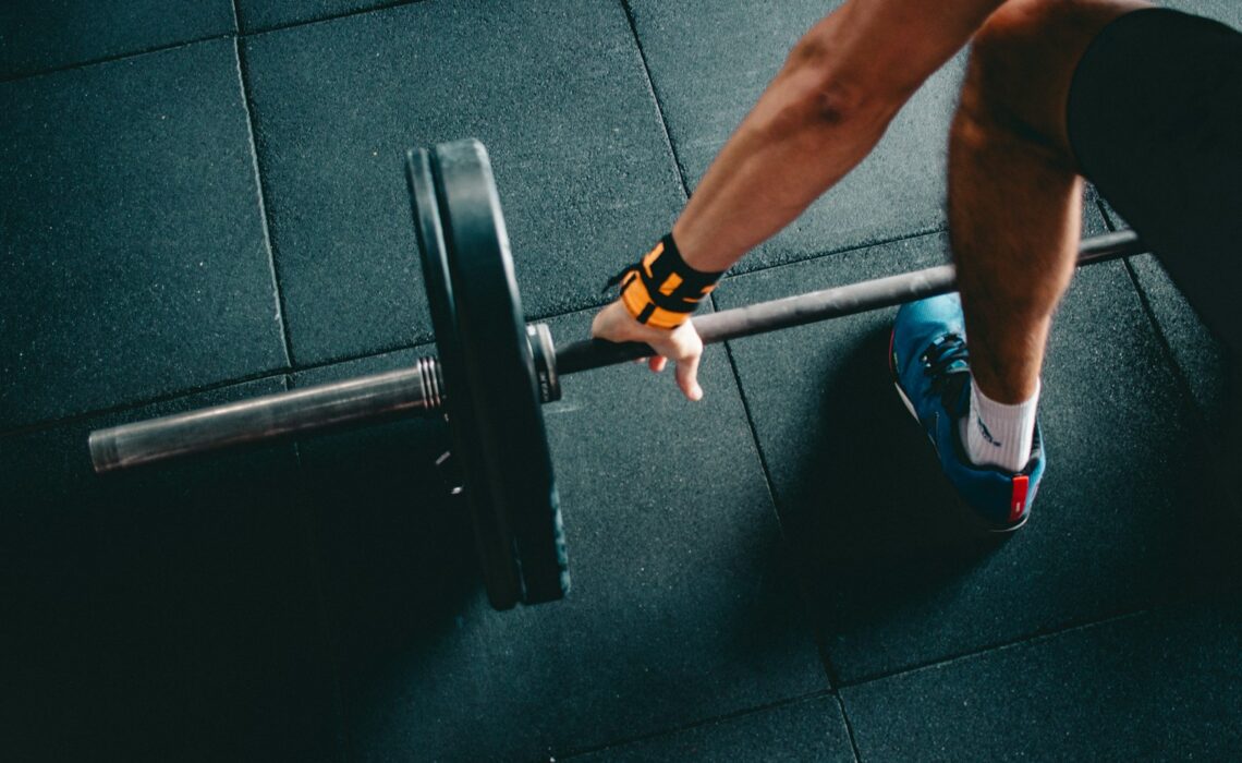 man holding black barbell