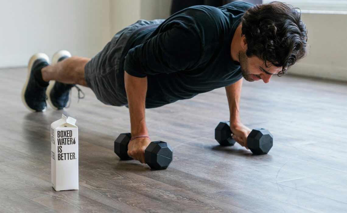 man in black t-shirt and black shorts doing push up