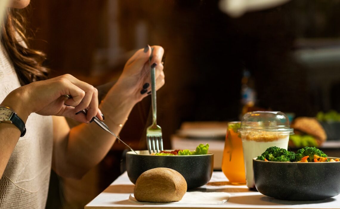 person holding silver fork and knife