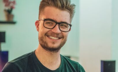 man wearing green crew-neck top and eyeglasses with black frames looking at side